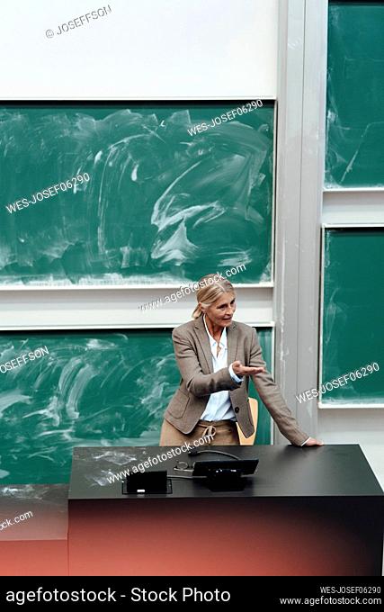 Businesswoman giving presentation in front of chalkboard