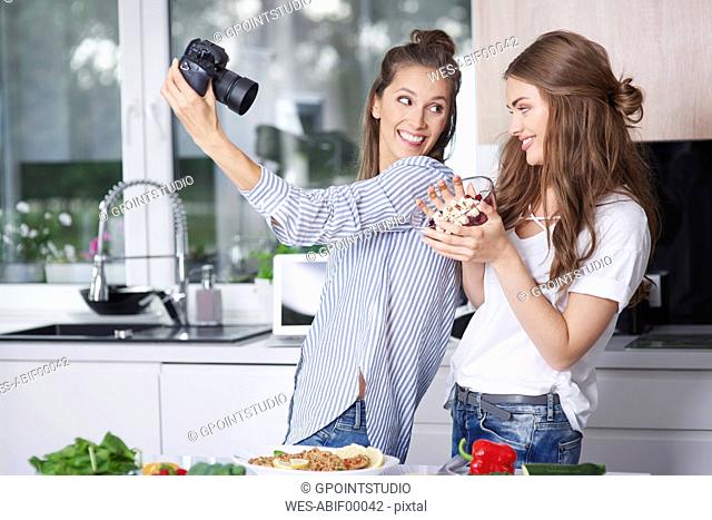 Food bloggers taking selfie with digital camera
