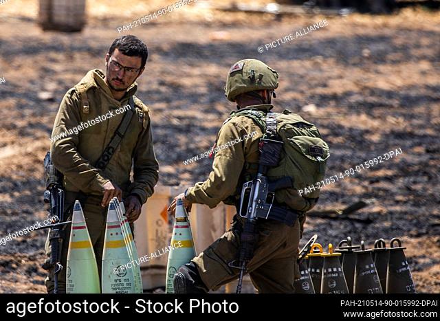 14 May 2021, Israel, Sderot: Israeli soldiers prepare to fire artillery shells towards the Gaza Strip at the Israeli Gaza border near Sderot