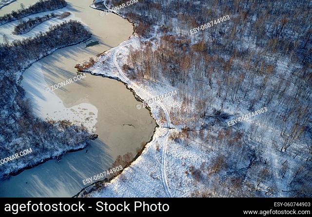 Aerial photo of Koen river under ice and snow. Beautiful winter landscape. Camera pointed down. Novosibirsk, Siberia, Russia