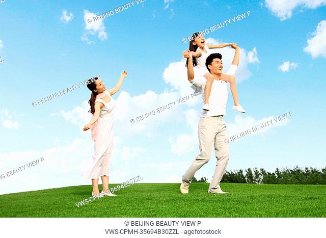 Girl with her parents on grass