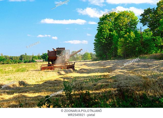 Old soviet combine harvester working in a field