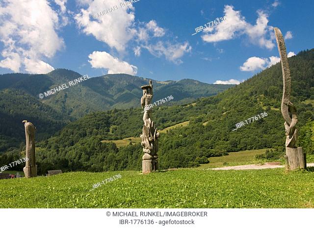Meadow with wooden statues in the High Tatras mountain range near Vlkolínec, Slowakia, Europe