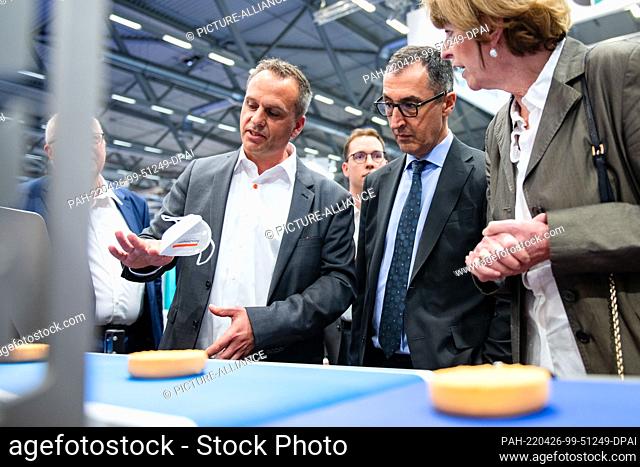 26 April 2022, North Rhine-Westphalia, Cologne: Federal Minister of Agriculture Cem Özdemir (r, Bündnis 90/Die Grünen) is shown a molding machine at the...