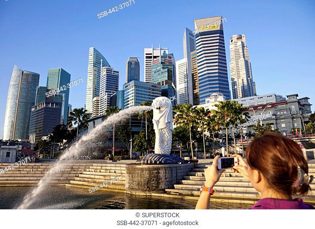Woman taking picture of skylines, Merlion Statue, Marina Bay, Singapore City, Singapore