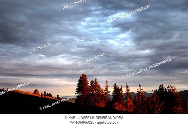 People enjoy the panoramic view of the Alps during sunset on the Auerberg mountain near Bernbeuren, Germany, 08 January 2013