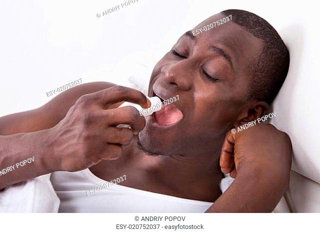 African Man Using Asthma Inhaler