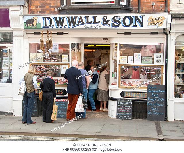 Customers queueing outside traditional butchers shop, Ludlow, Shropshire, England, september