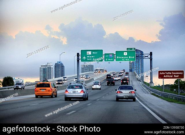 Miami, FL, USA - May 12, 2013: Evening traffic on highway, Miami, USA. Cars moving on a highway with directional signs to Miami International airport