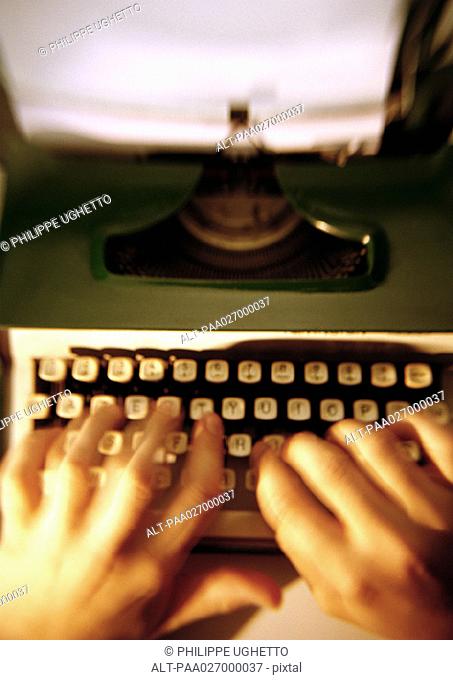 Hands typing on typewriter