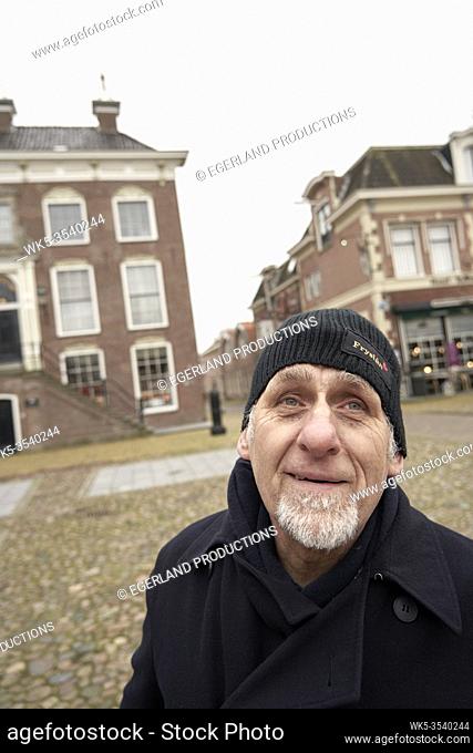 Friesian senior man in front of city hall of Workum, Friesland, Netherlands