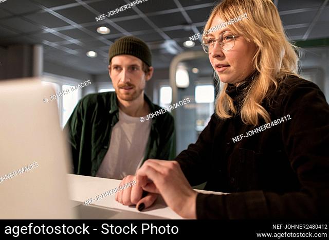 Woman in office looking at laptop screen