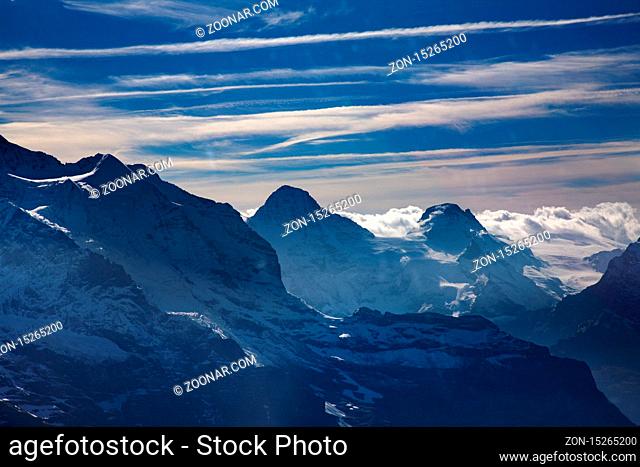 Three famous Swiss mountain peaks, Eiger, Mönch and Jungfrau with blue sky and clouds