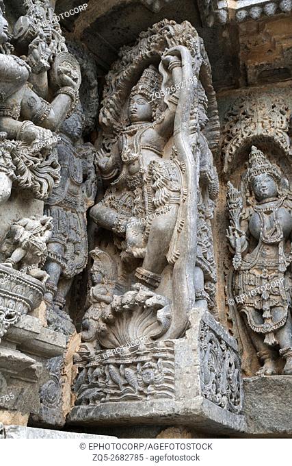 Ornate wall panel reliefs depicting Krishna dancing on the head of serpant Kalia and eventually killing him. Kedareshwara temple, Halebidu, Karnataka, india