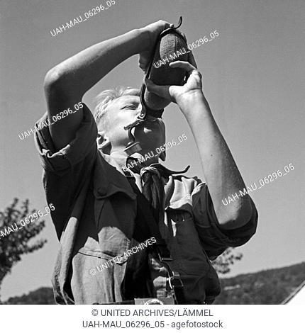 Durstiger Hitlerjunge trinkt aus seiner Feldflasche im Hitlerjugend Lager, Österreich 1930er Jahre. Thirsty Hitle youth dirnking from his water bottle at the...