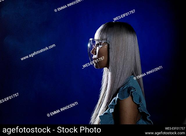 Young woman with visor glasses against blue background