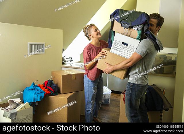 Young couple with boxes moving in to new home