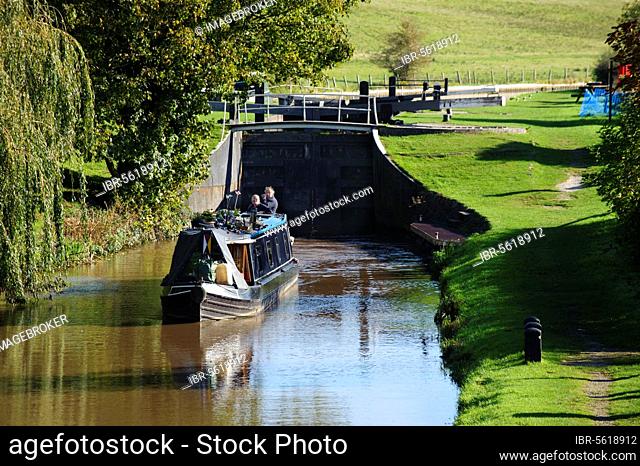 Narrow boat leaving canal lock, built of iron due to sandy ground conditions, Beeston Iron Lock, Shropshire Union Canal, Beeston, Tarporley, Cheshire, England