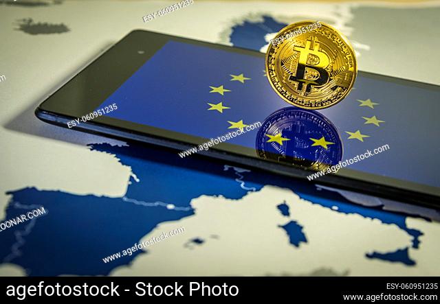 Financial concept with golden Bitcoin over smartphone, UE flag and map. Situation of Bitcoin and other cryptocurrencies in European Union concept