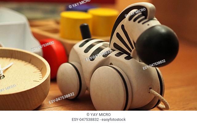 Many colorful baby wood toys on light brown color carpet which include ball, airplane, bus and others that helps development baby's EQ and IQ and make baby have...