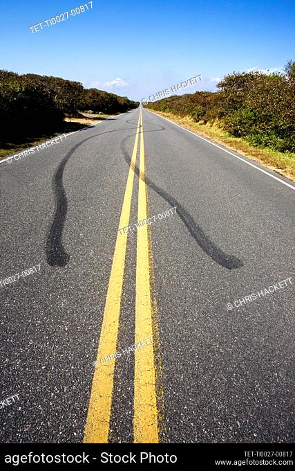 Estados Unidos, Massachusetts, huellas de neumáticos y doble línea amarilla en la carretera vacía