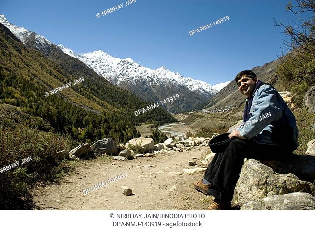 Person watching Chitkul Valley & snow covered mountains at Sangla Valley ; Himachal Pradesh ; India