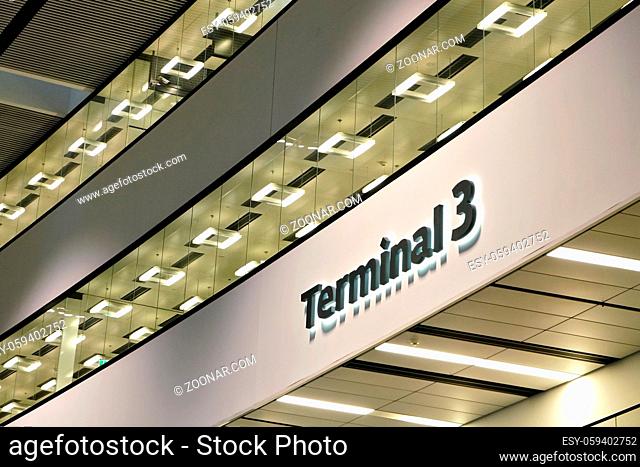 Black Terminal 3 sign in airport hall