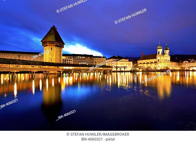 Chapel Bridge with a water tower and Jesuit Church on the Reuss River at dusk, historic town centre, Lucerne, Canton of Lucerne, Switzerland