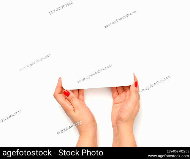 Female hands hold an empty rectangular disposable plastic container on a white background, top view