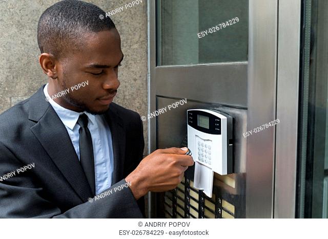 Young African Businessman Entering Code In Security System