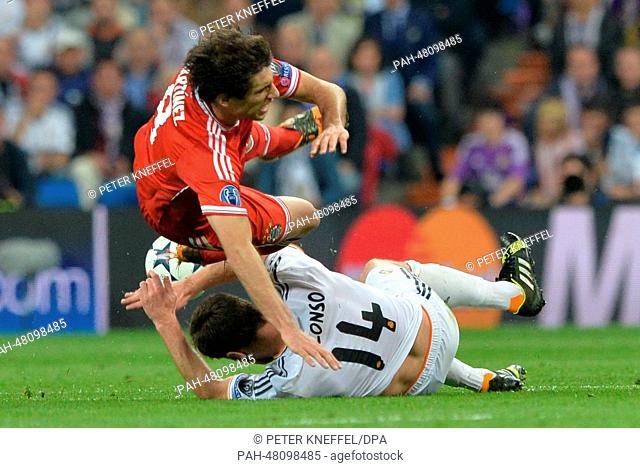 Munich's Javi Martinez (L) and Xabi Alonso of Real Madrid vie for the ball during the UEFA Champions League semi final first leg soccer match between Real...