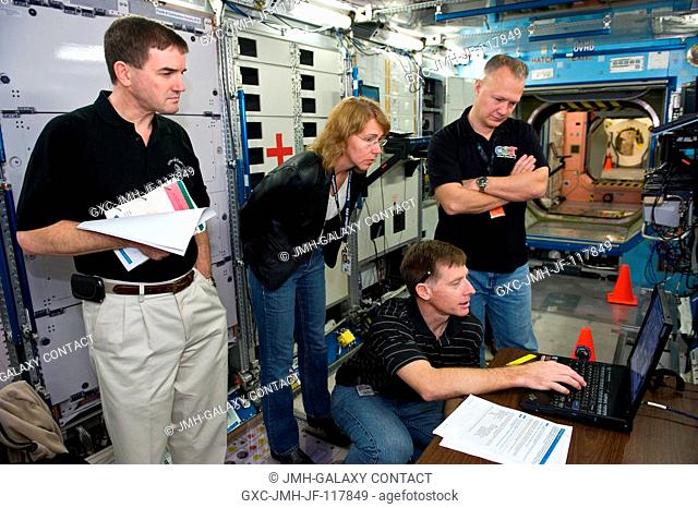 NASA astronauts Chris Ferguson (kneeling), STS-135 commander; Doug Hurley, pilot; Rex Walheim (left) and Sandy Magnus, both mission specialists