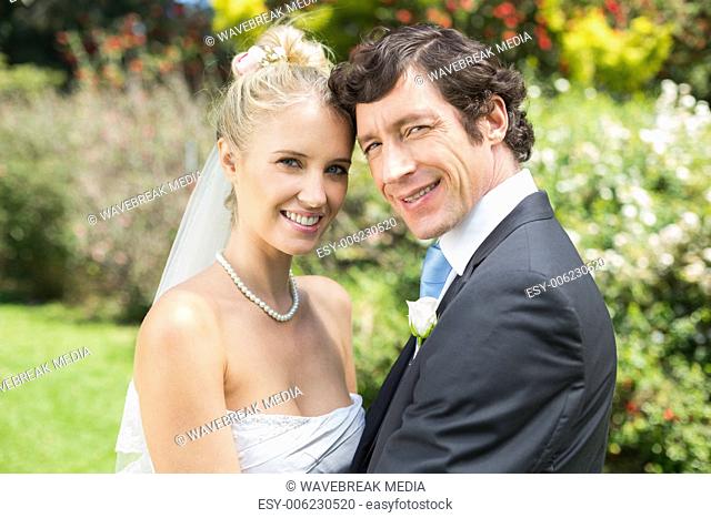Pretty blonde wife hugging her new husband smiling at camera