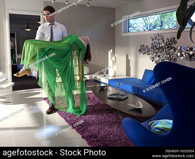 Contemporary vintage inspired portrait of a man holding a passed out woman in a Mid-Century modern home