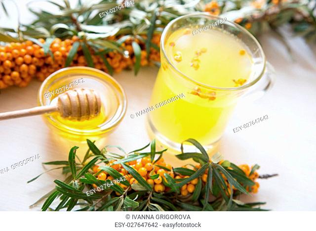 tea with sea buckthorn and honey on a light background. Selective focus