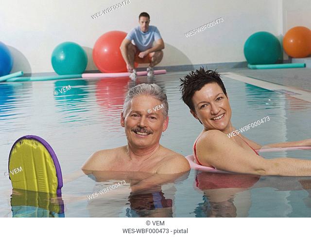 Germany, Nuremberg, Couple in pool with man in background