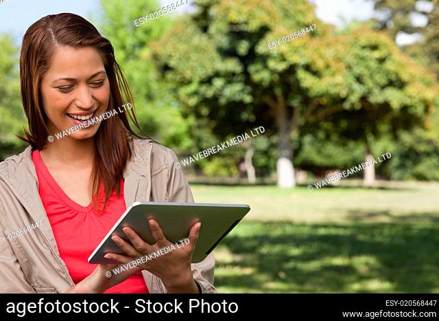 Young woman smiling enthusiastically while using a tablet