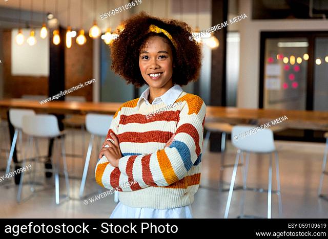 Portrait of mixed race smiling businesswoman standing in a meeting room