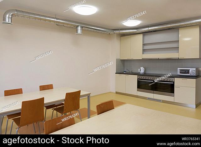 Modern youth hostel building. Kitchen and eating areas. Two ovens, kettle and toaster