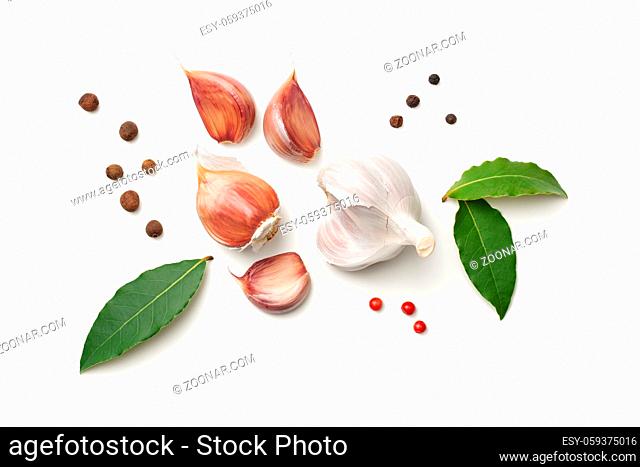Garlic, bay leaves, allspice and pepper isolated on white background. Top view