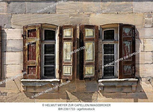 Historic windows with shutters, detailed view of a brownstone house built in the 18th century, under monumental protection, not yet restored