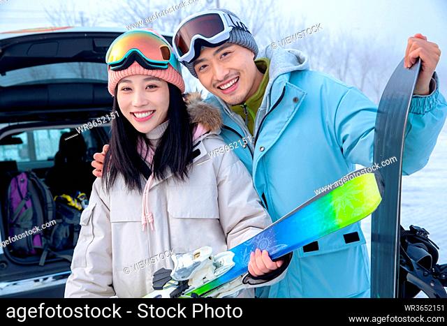 Happy young couples with skis z stand together