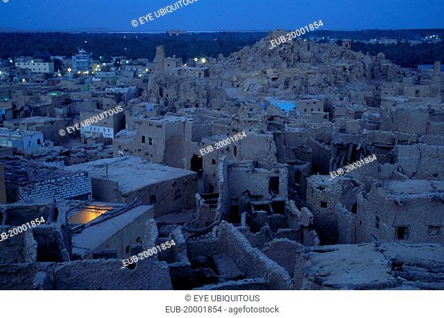 View across town towards Shali Fortress at night with oasis in the background