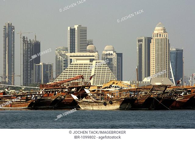 Dhows, wooden freight ships, Doha Bay, newly constructed buildings, high rise district on the north bank of the Corniche, Doha Sheraton Hotel in the centre