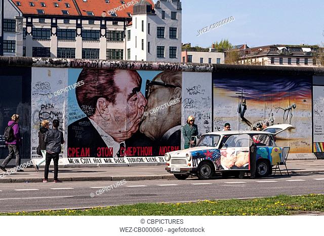 Germany, Berlin, Trabant in front of mural painting of brotherly kiss between Leonid Brezhnev and Erich Honecker