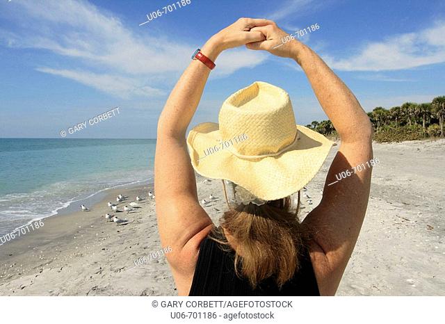 Senior woman at Casperson Beach in Venice (Florida, USA) with arms in a circle