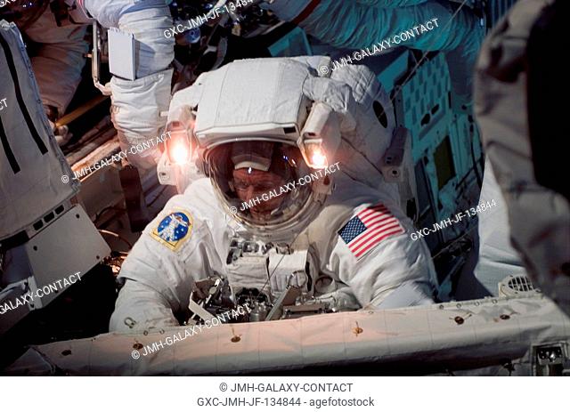 Astronaut Michael E. Fossum, STS-121 mission specialist, repositions tethers at the forward bulkhead of the Space Shuttle Discovery after completing the Orbiter...