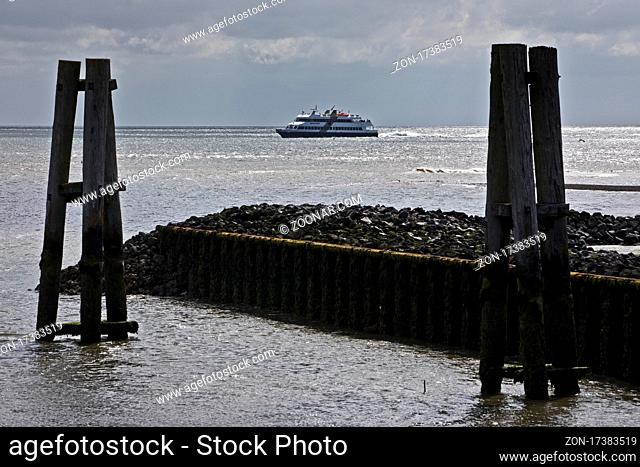 Blick vom Anleger in Amrum auf die Nordsee mit dramatischer Stimmung und einem Schiff am Horizont, Schleswig-Holstein, Deutschland, Europa