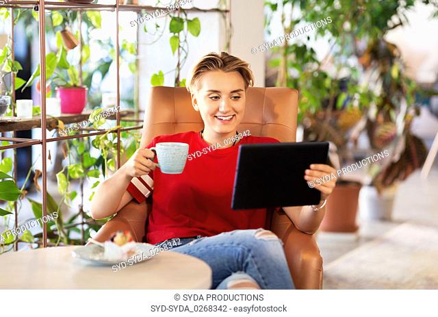 happy woman with tablet pc at cafe or coffee shop