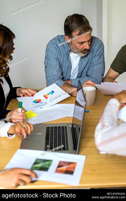 Male and female entrepreneurs planning strategy during meeting at office